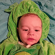 Theodore is registered to the contest to win money with this photo: baby, child, hoodie, green, blanket, portrait, face, infant, cute, soft, clothing, indoor, young, warm, expression, person, button, head, fabric, comfort