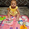Miracle is registered to the contest to win money with this photo: baby, child, yellow_dress, pout, play_mat, toy_microphone, toy_keyboard, toy_maracas, toy_drums, indoor, carpet, floor, cute, smiling, musical_toys, infant, sitting, face, expression, funny