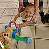 baby, walker, toy, adult, dog, floor, tile, support, smile, child, indoor, play, learning, cute, person, footwear, jeans, earring, necklace, hand