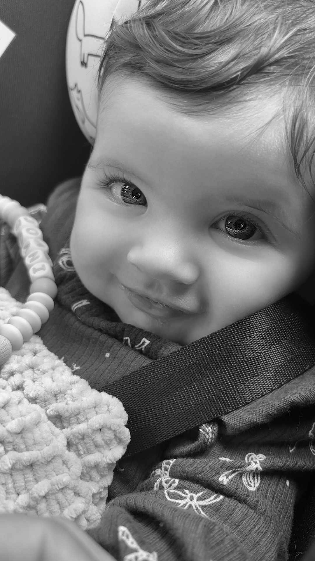Joani joined the competition — help win amazing prizes! baby, child, smiling, black_and_white, close_up, face, eyes, blanket, car_seat, toy, beads, clothing, cute, infant, portrait, happy, seatbelt, texture, young, person