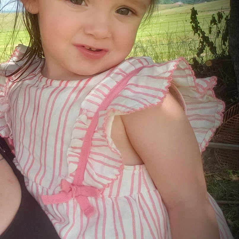 Ayeslynn is registered to the contest to win money with this photo: child, clothing, cute, dress, expression, field, girl, greenery, headband, nature, outdoor, person, pink, portrait, summer, sunlight, toddler, tree, white, young