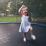 Ayeslynn joined the competition — help win amazing prizes! child, girl, trampoline, outdoor, grass, trees, dress, sandals, smiling, playing, motion_blur, nature, summer, happy, backyard, recreation, fun, person, jumping, daylight