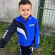 Jayden participe au concours pour gagner de l'argent avec cette photo : boy, casual, child, daylight, fence, grass, gravel, haircut, happy, jacket, nike, outdoor, person, portrait, shoes, smiling, sportswear, standing, wall, yamaha