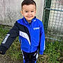 boy, casual, child, daylight, fence, grass, gravel, haircut, happy, jacket, nike, outdoor, person, portrait, shoes, smiling, sportswear, standing, wall, yamaha