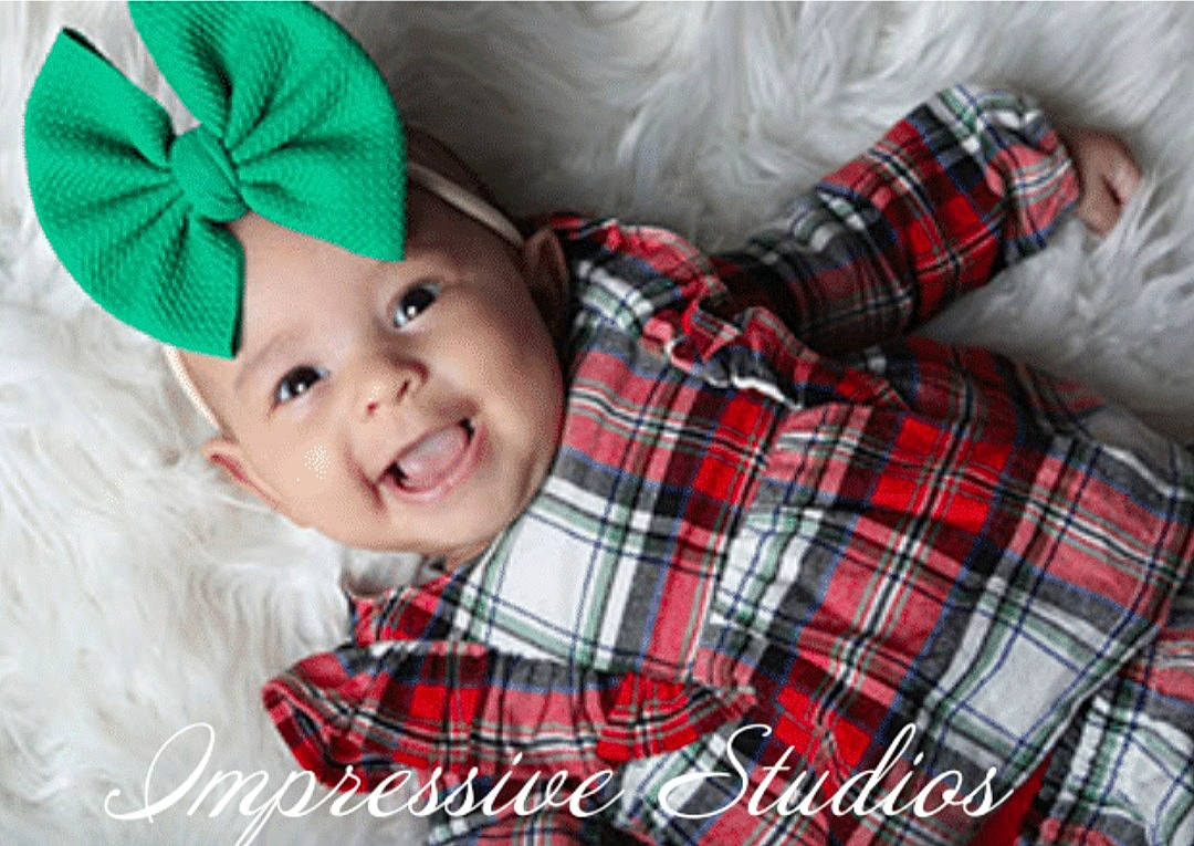 Lydia is registered to the contest to win money with this photo: baby, baby_toddler_clothing, child, christmas, comfort, face, green, happy, hat, head, headwear, joy, outerwear, pattern, person, plaid, red, sleeve, smile, tartan
