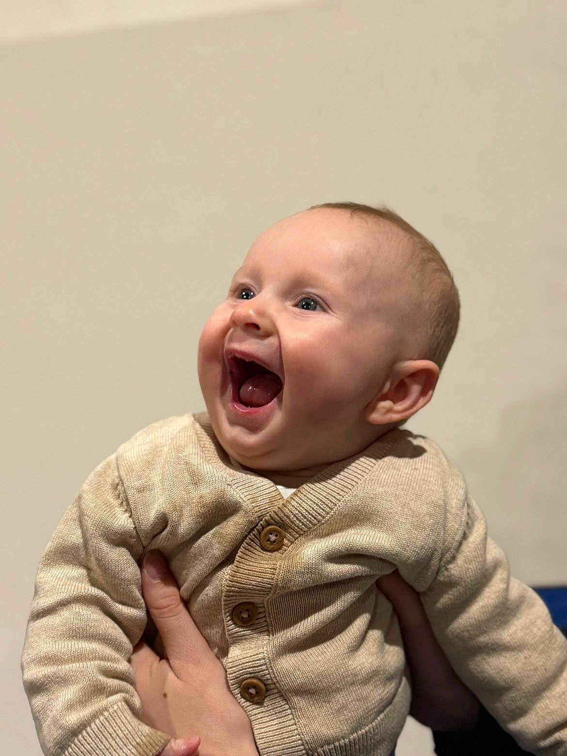 Charlie participe au concours pour gagner de l'argent avec cette photo : baby, child, infant, laughing, smiling, cardigan, beige, hand, person, cute, happy, portrait, indoor, human, young, face, expression, clothing, warm, fun