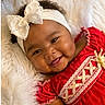 baby, bow, child, close_up, curly_hair, dark_skin, fashion, fluffy_blanket, hair_bow, happy, indoor, infant, lace, lying_down, photography, portrait, red_dress, smiling, white_blanket, white_headband