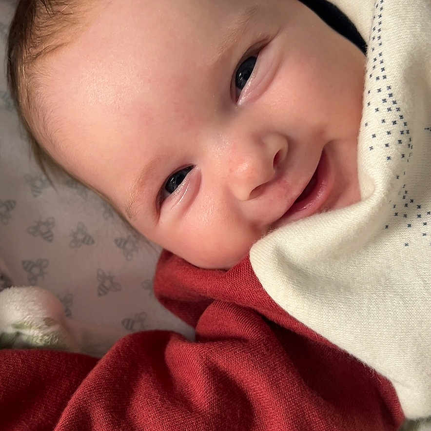 Sophia is registered to the contest to win money with this photo: baby, blanket, bodypart, clothing, face, finger, furniture, hand, happy, head, homedecor, knitwear, newborn, person, photography, portrait, quilt, smile, sweater, sweatshirt
