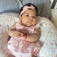 Jessenia joined the competition — help win amazing prizes! baby, infant, pink_dress, headband, bracelet, floral_cushion, cute, indoors, portrait, child, skin, face, hands, lying_down, soft_light, plush, cozy, adorable, resting, young_child