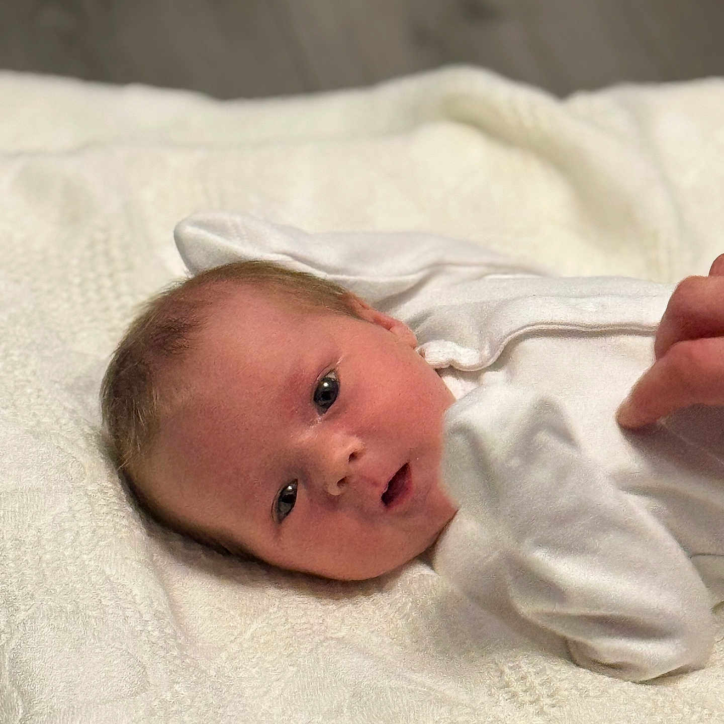 Minnie joined the competition — help win amazing prizes! baby, closeup, cute, expression, face, hand, head, indoor, infant, lying_down, newborn, newborn_baby, person, portrait, skin, sleepwear, soft_texture, white_blanket, white_clothing, young_child