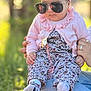 Omnia a rejoint le concours — aidez-le/la à gagner de superbes lots ! baby, child, sunglasses, pink_headband, pink_cardigan, floral_outfit, pacifier_clip, socks, outdoor, grass, person, holding_hands, jeans, sunlight, portrait, cute, fashion, accessory, headwear, closeup