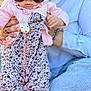baby, child, sunglasses, pink_cardigan, floral_onesie, hand, adult, blue_shirt, jeans, person, fashion, outdoor, portrait, cute, infant, clothing, accessory, holding, casual, cool