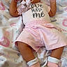 baby, infant, pacifier, pink_clothing, headband, bow, blanket, pattern, animal_print, lying_down, cute, child, soft_toys_pattern, socks, comfortable, indoors, sleepy, adorable, young_child, pastel_colors