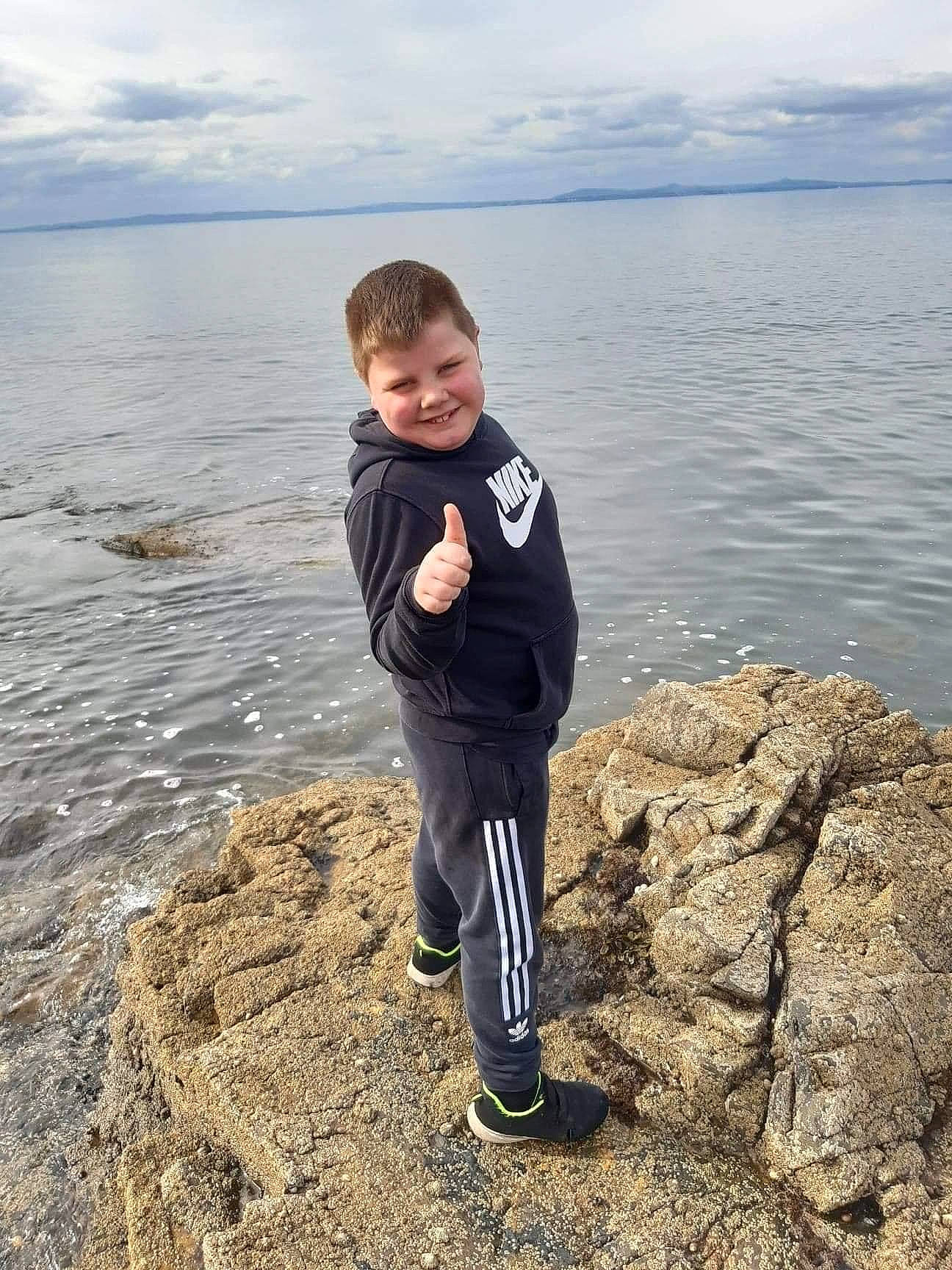 Darren is registered to the contest to win money with this photo: beach, child, cloud, coast, coastal_and_oceanic_landforms, fun, happy, horizon, joy, lake, landscape, people_in_nature, person, rock, shore, sky, smile, standing, toddler, water