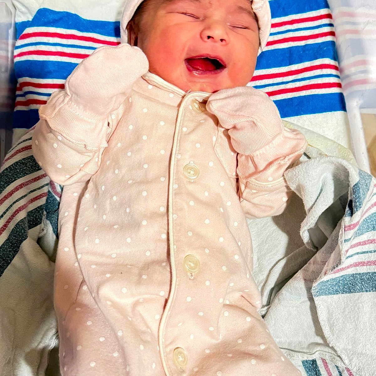 Mariam joined the competition — help win amazing prizes! baby, newborn, infant, pink_onesie, mittens, smiling, lying_down, hospital_blanket, striped_blanket, cute, happy, child, sleepwear, face, portrait, soft_lighting, indoor, newborn_clothes, baby_hat, toddler
