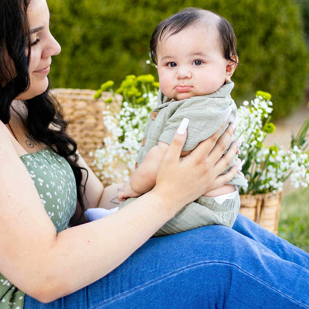 Giovanne is registered to the contest to win money with this photo: affection, baby, casual_clothing, child, cute, daylight, flowers, garden, green_top, greenery, holding, jeans, mother_and_child, nature, outdoor, portrait, pouting, smile, tender, woman