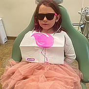 Zaylia joined the competition — help win amazing prizes! child, girl, sunglasses, dental_chair, dental_office, bib, pink_tutu, purple_hair, white_shirt, floor, medical_equipment, plastic_cover, person, indoor, waiting, seat, smile, cool, young, casual