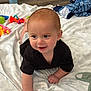 Nathaniel joined the competition — help win amazing prizes! baby, crawling, black_shirt, blanket, toy, bottle, floor, indoor, smiling, child, infant, person, cute, happy, head, hand, face, clothing, wooden_floor, playtime