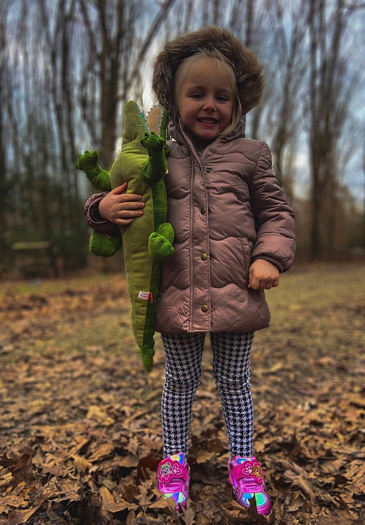 Sophiya is registered to the contest to win money with this photo: boot, child, footwear, forest, fruit, fun, grass, happy, jacket, joy, outerwear, people_in_nature, person, plant, shoe, smile, sneakers, soil, standing, toddler