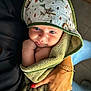 baby, child, towel, hood, blue_eyes, hand, bracelet, nail_polish, green, animal_print, cute, wrapped, snug, soft, indoor, person, portrait, holding, skin, infant