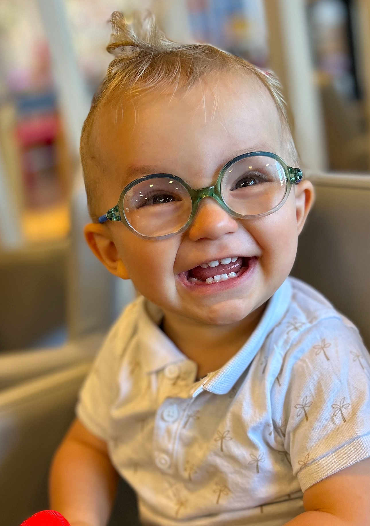 Maloë participe au concours pour gagner de l'argent avec cette photo : toddler, child, glasses, smile, happy, indoor, shirt, short_sleeve, teeth, hair, face, person, young_child, seated, cute, portrait, baby, light, background_blur, joyful
