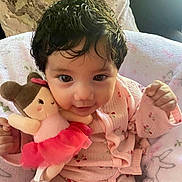 Layla joined the competition — help win amazing prizes! baby, child, doll, pink_pajamas, cute, smiling, indoor, soft_blanket, plush_toy, infant, face, portrait, cozy, seated, happy, young_child, person, toy, closeup, curly_hair