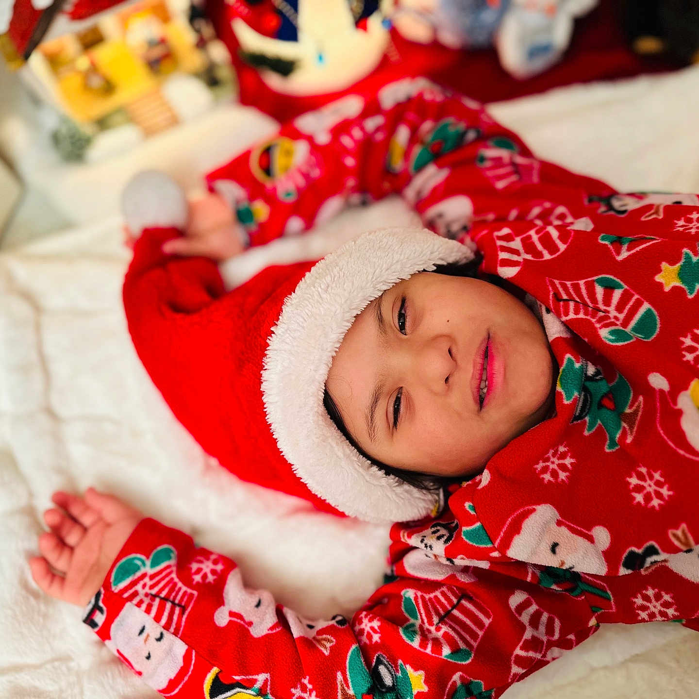 João Pedro joined the competition — help win amazing prizes! blanket, celebration, child, christmas, cozy, cute, face, festive, happy, holiday, indoors, lying_down, pajamas, person, red_clothing, relaxed, santa_hat, seasonal, smiling, winter