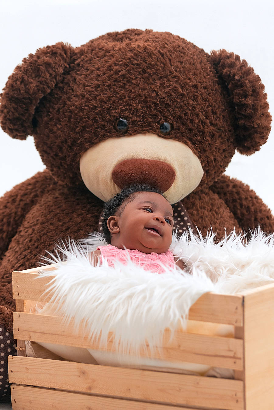Nyla is registered to the contest to win money with this photo: baby, cap, child, costume_hat, fur, happy, head, headgear, knit_cap, mammal, outerwear, person, plush, smile, stuffed_toy, teddy_bear, textile, toy, vertebrate, wood