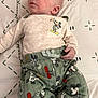 baby, infant, mickey_mouse, clothing, pants, long_sleeve, blanket, pattern, bed, laying_down, cute, child, young, person, fabric, sleepwear, cartoon, character, soft, comfort