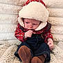 baby, infant, plaid_jacket, hood, brown_socks, denim_pants, blanket, soft_texture, cozy, cute, child, sitting, indoors, warm_clothing, face, small_hands, fur_trim, casual_wear, portrait, young