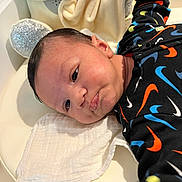 Wassim participe au concours pour gagner de l'argent avec cette photo : baby, babywear, black_outfit, child, closeup, clothing, colorful_pattern, cute, expression, face, head, indoors, infant, lying_down, newborn, plush_toy, portrait, skin, soft_texture, white_cloth