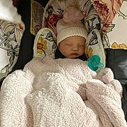Kaislee joined the competition — help win amazing prizes! baby, blanket, car_seat, child, cozy, floral_pattern, hat, infant, pacifier, pink, pom_pom, resting, sleeping, soft_texture, toddler, warm, wearing, young_child, face, indoor