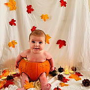 Victoire a rejoint le concours — aidez-le/la à gagner de superbes lots ! autumn_leaves, baby, blanket, candles, child, cozy, cute, decor, fall_theme, festive, holiday, indoor, orange, pine_cones, portrait, pumpkin, red, seasonal, smiling, yellow