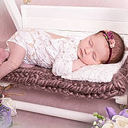 Victoire participe au concours pour gagner de l'argent avec cette photo : baby, sleeping, infant, lace_outfit, headband, flower, flowers, swing, knitted_cushion, white_wood, pink_background, cute, peaceful, portrait, newborn, soft_texture, resting, decor, indoor, child