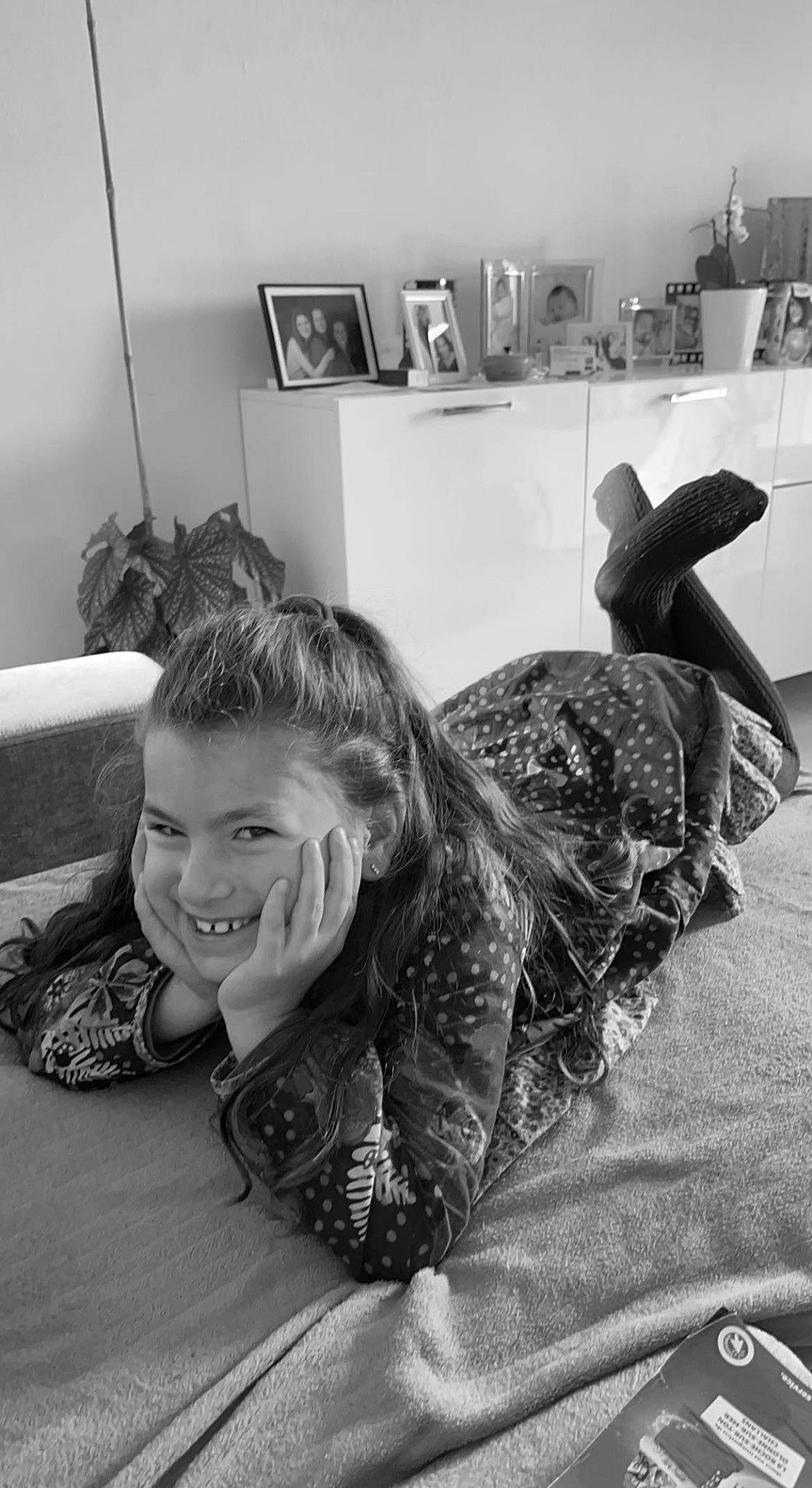 Melyna a rejoint le concours — aidez-le/la à gagner de superbes lots ! black_and_white, child, comfort, elbow, flooring, fun, fur, gesture, happy, joy, monochrome, monochrome_photography, pattern, person, picture_frame, portrait_photography, room, shelf, sitting, smile