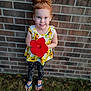 Adalynn is registered to the contest to win money with this photo: barefoot, blue_eyes, brick_wall, cheerful, child, floral_top, foreground_subject, girl, grass, hair_bun, holding_flower, outdoors, polka_dot_leggings, portrait, red_flower, sandals, shallow_depth_of_field, smiling, toddler, wall_texture