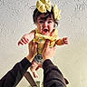 arms, baby, ceiling_fan, child, clothing, cute, expression, hands, happy, headband, holding, indoor, infant, person, playful, portrait, sleeves, smiling, textured_ceiling, yellow_bow