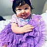 Emmarie Grace is registered to the contest to win money with this photo: baby, child, tutu, purple, headband, smile, cute, portrait, clothing, infant, person, indoor, soft_light, happy, sitting, face, young_child, fashion, cute_outfit, closeup