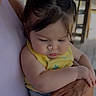arm, baby, casual_clothing, child, cute, daylight, expression, hair, hand, holding, infant, natural_light, outdoor, person, pigtails, porch, shorts, skin, yellow_top, young_child