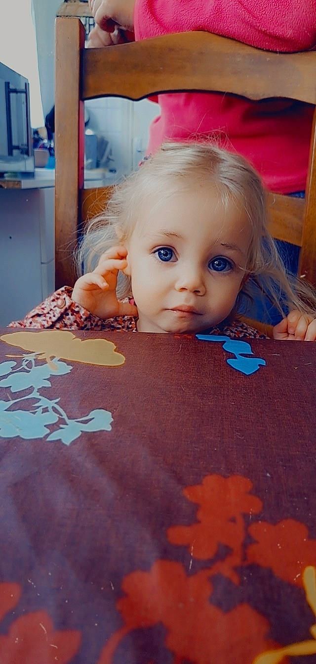 Lea participe au concours pour gagner de l'argent avec cette photo : azure, baby, cheek, child, eye, eyelash, facial_expression, floor, flooring, fun, hardwood, iris, orange, pattern, people, person, room, skin, textile, toddler