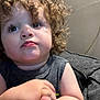 Rene joined the competition — help win amazing prizes! toddler, child, curly_hair, face, hands, gray_shirt, indoor, couch, expression, skin, portrait, person, young, sitting, closeup, cute, curiosity, light, shadow, background