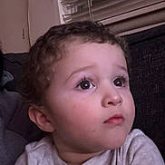 Rene joined the competition — help win amazing prizes! toddler, child, face, curly_hair, indoors, window_blinds, couch, expression, looking_away, soft_lighting, long_eyelashes, sweater, young_child, portrait, person, skin, head, casual_clothing, seated, home
