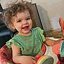 Luna joined the competition — help win amazing prizes! toddler, child, curly_hair, green_shirt, baby_chair, toy, smile, happy, indoor, person, play, seat, furniture, face, hand, young_child, cute, expression, colorful