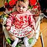 baby, child, valentines_day, pink_clothing, socks, roses, flower_pattern, cushion, chair, indoor, cute, portrait, infant, sitting, looking_up, white_socks, floor, wooden_floor, pink_skirt, heart_pattern