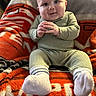baby, child, infant, smile, face, hands, pajamas, socks, blanket, orange, gray, cozy, seated, indoor, cute, happy, portrait, soft, plush, warm