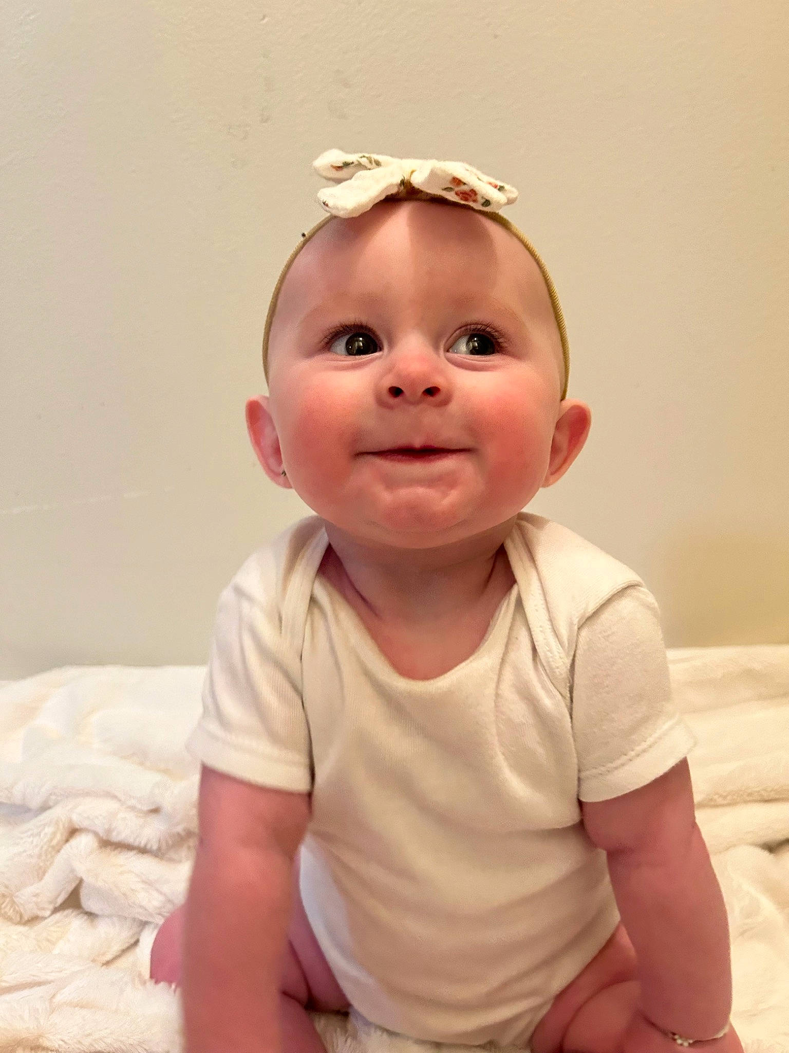 Emilia is registered to the contest to win money with this photo: baby, baby_toddler_clothing, cheek, child, comfort, face, flooring, fun, happy, head, headband, iris, lip, mouth, nose, person, sitting, skin, sleeve, smile