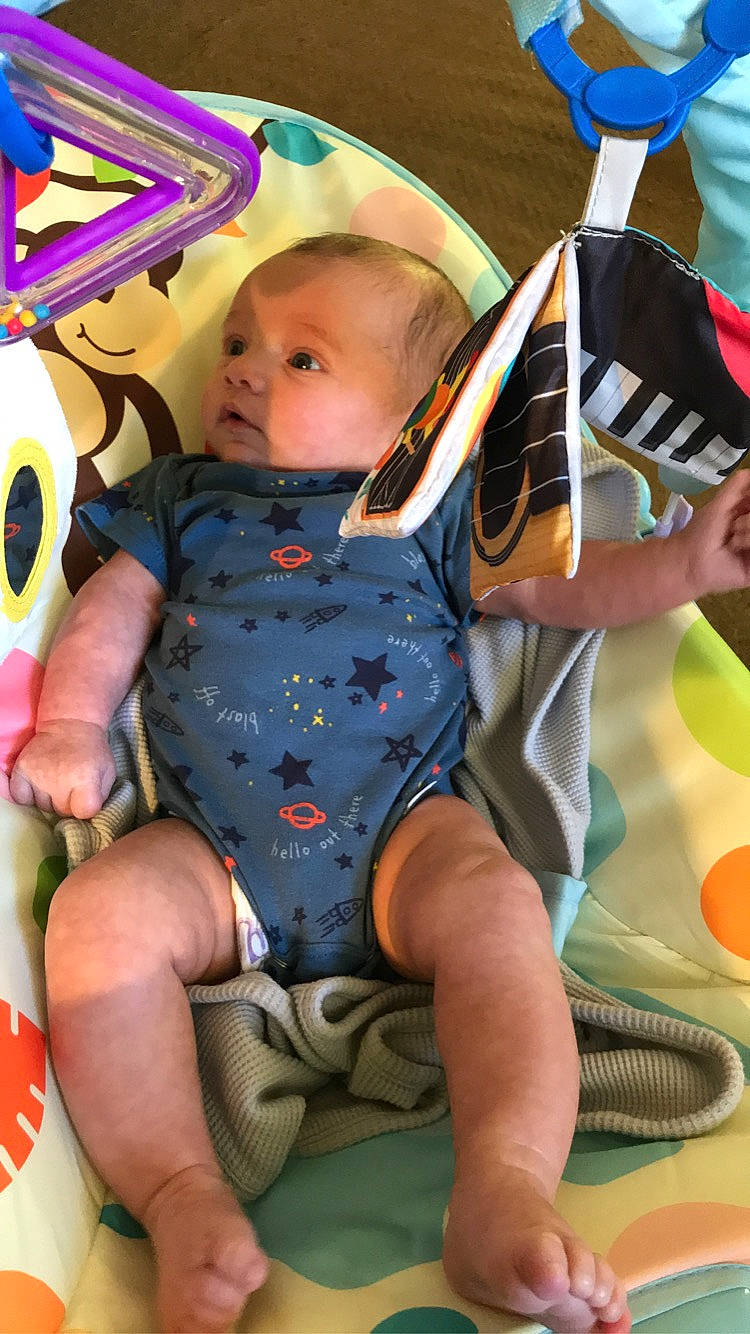 Kyler is registered to the contest to win money with this photo: baby, baby_carriage, baby_products, baby_toddler_clothing, blue, child, comfort, electric_blue, fun, happy, human_leg, lap, leg, leisure, pattern, person, recreation, sitting, thigh, toddler