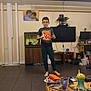 Tyler joined the competition — help win amazing prizes! child, boy, indoor, living_room, tshirt, glasses, barefoot, television, fish_tank, table, cup, sippy_cup, clutter, floor, furniture, picture_frame, electronics, person, casual, home