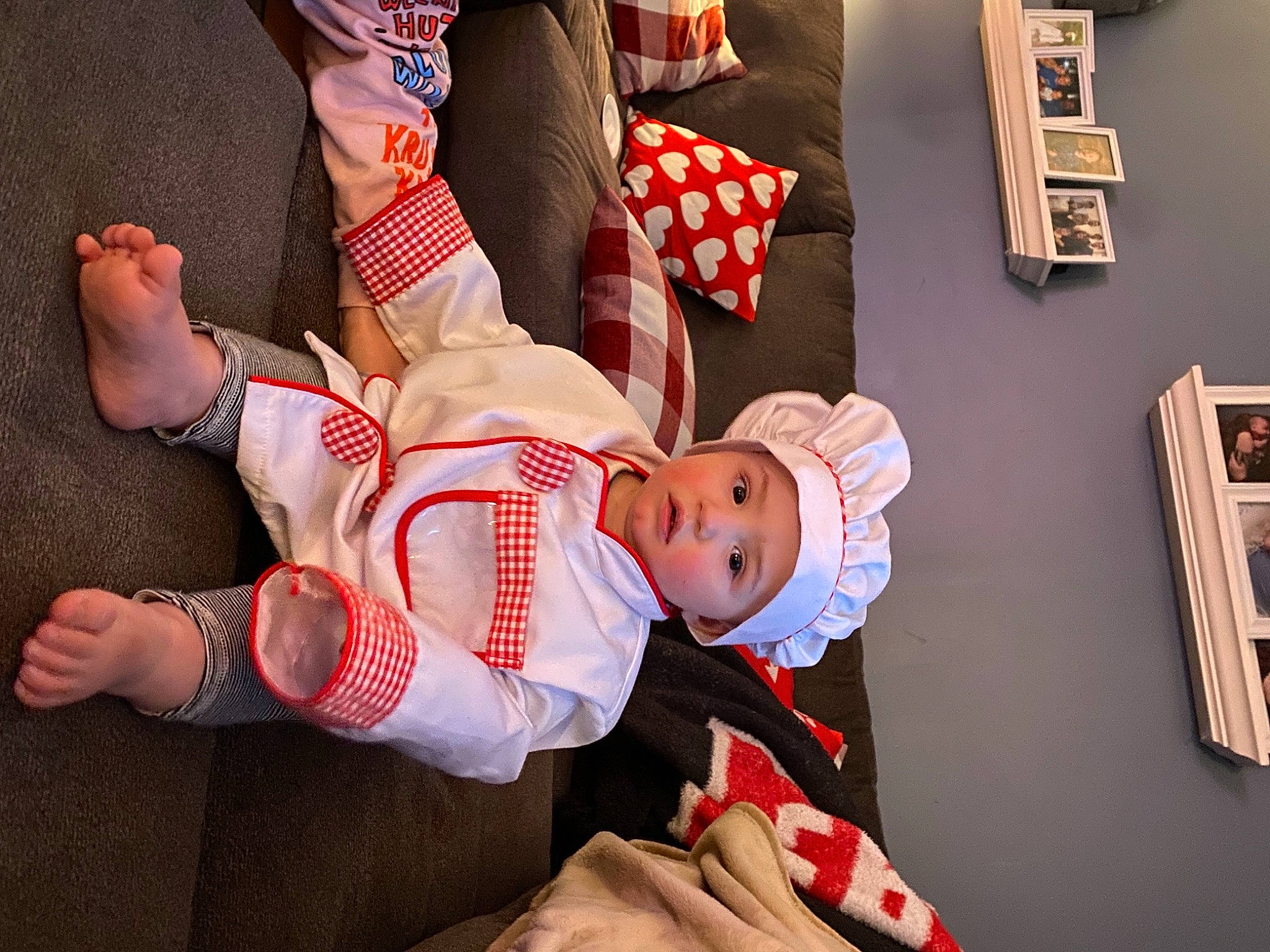 Conrad joined the competition — help win amazing prizes! baby, bookcase, child, event, finger, flag_of_the_united_states, fun, gesture, hand, happy, hat, headwear, human_leg, knee, lap, leg, person, picture_frame, shelf, sock