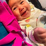 Layloni is registered to the contest to win money with this photo: baby, smiling, infant, face, happy, clothing, blanket, pink, fabric, cute, child, portrait, closeup, indoor, cozy, warm, person, expression, lying_down, colorful